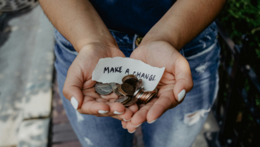 woman holding change to make a change